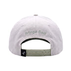 The back of a light gray washed baseball cap with 'Fringe Golf' embroidered in green on the front panel and an adjustable olive green plastic snapback strap.
