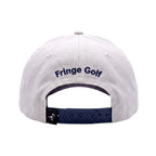 The back of a white cotton baseball cap with 'Fringe Golf' embroidered in navy blue on the crown and a navy blue adjustable strap.