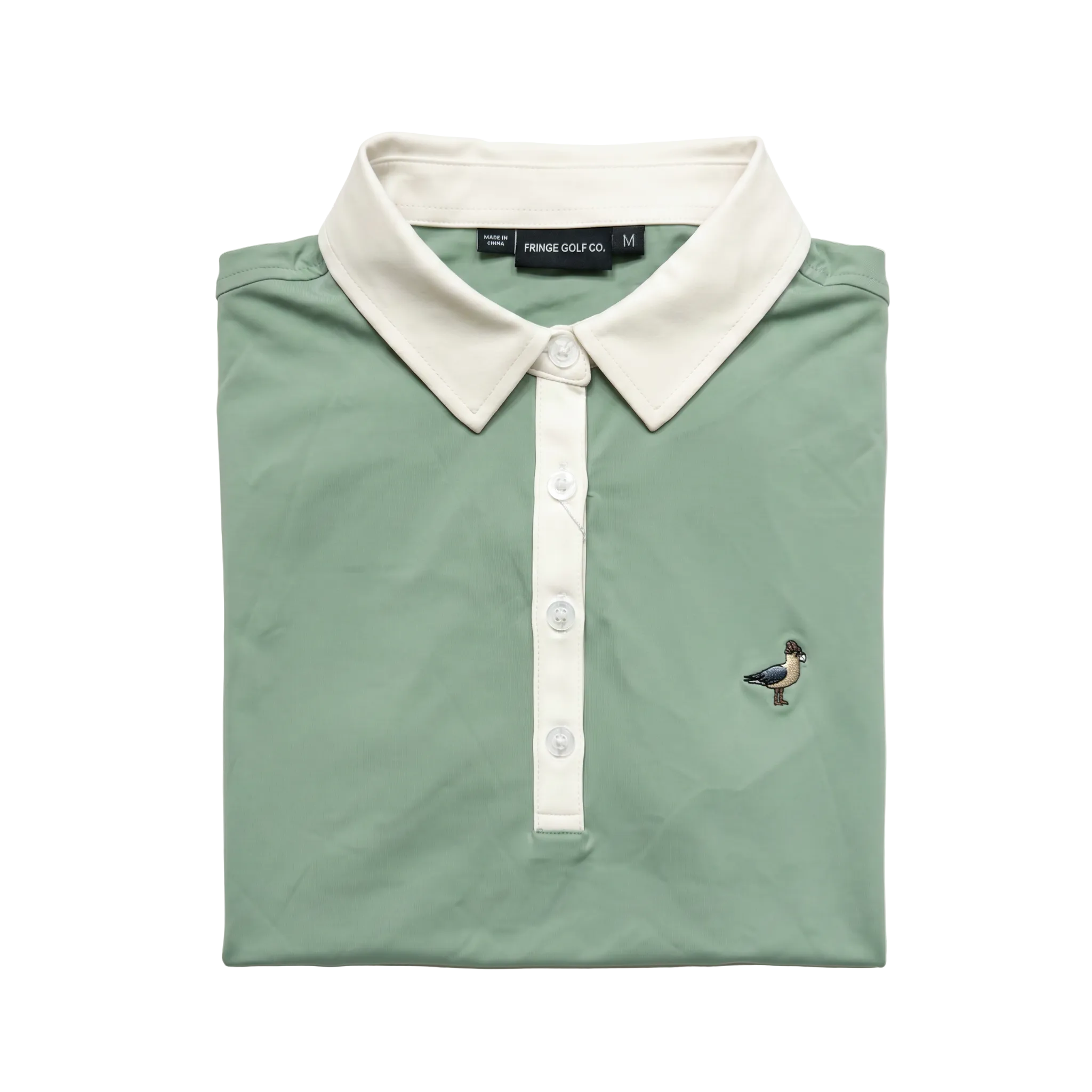 Folded green polo shirt with white collar and buttons on a light gray background